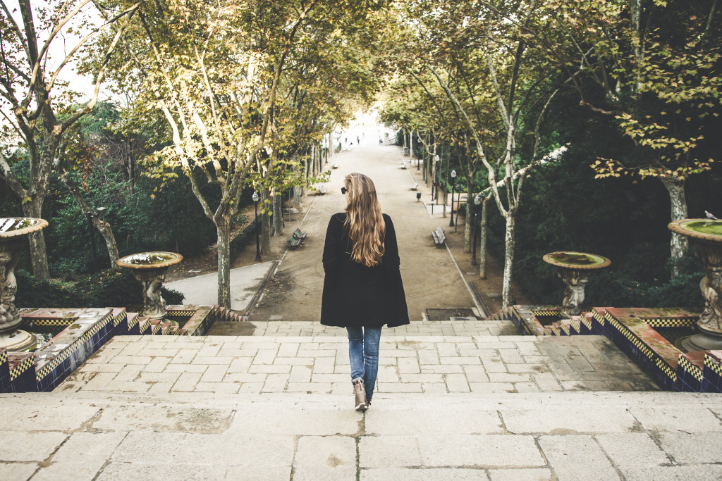 woman walking in a park between trees